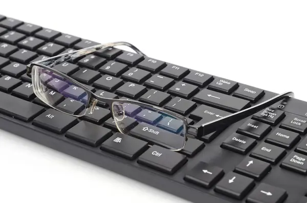 コンピューターのキーボードと眼メガネ — ストック写真
