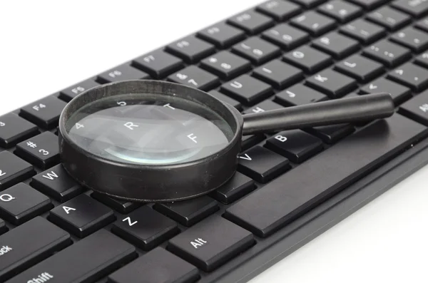Computer keyboard and magnifier — Stock Photo, Image