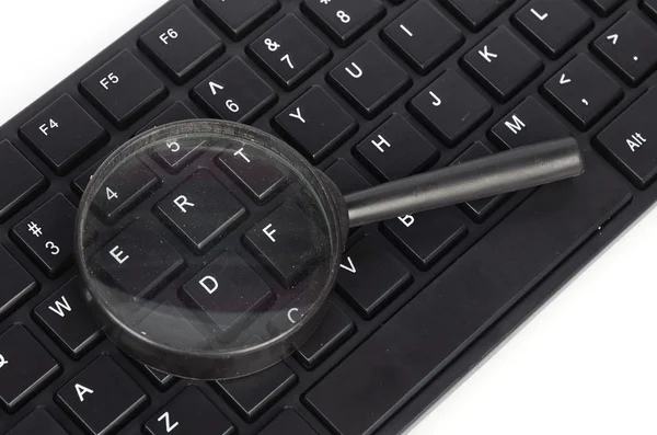 Computer keyboard and magnifier — Stock Photo, Image