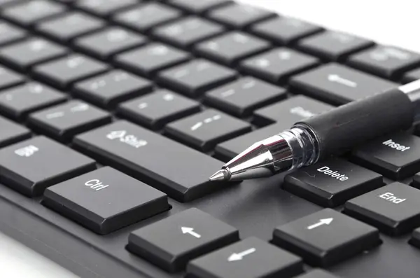 Комп'ютерна клавіатура і ручка — стокове фото