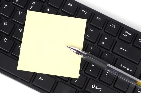Комп'ютерна клавіатура та нотатка з ручкою — стокове фото