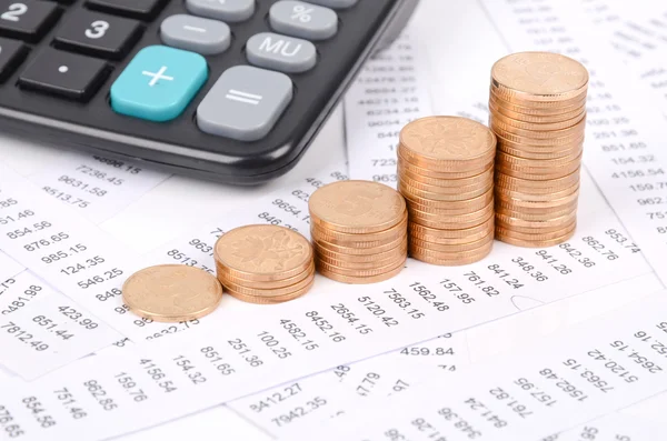 Příjmy, kalkulačka a mince — Stock fotografie