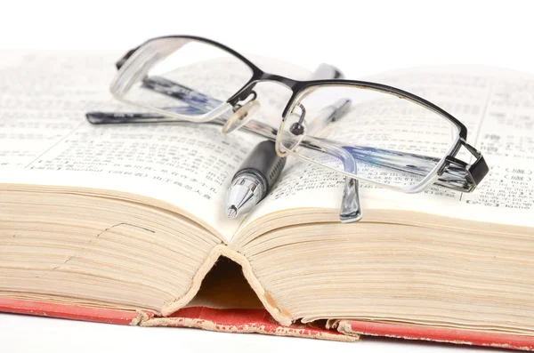 Stylo et lunettes avec livre — Photo