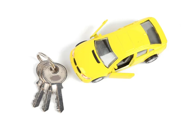 Carro de brinquedo e chave no fundo branco — Fotografia de Stock