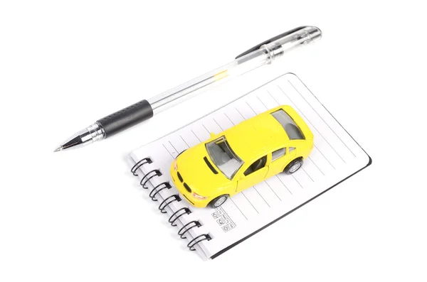 Oyuncak araba, kalem ve not defteri — Stok fotoğraf