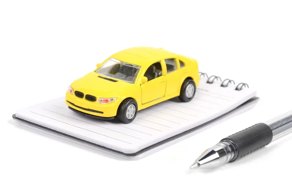 Oyuncak araba, kalem ve not defteri — Stok fotoğraf