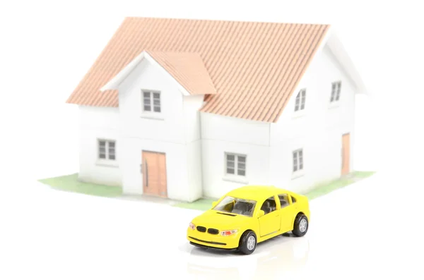 Leksaksbil och hus på vit bakgrund — Stockfoto