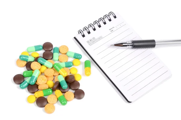 Medicine and notepad with pen — Stock Photo, Image