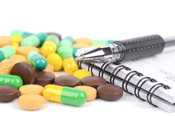 Medicina e bloco de notas com caneta — Fotografia de Stock