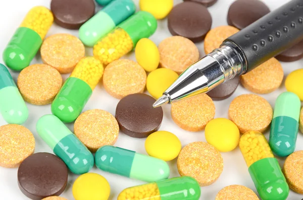 Medicina e penna su sfondo bianco — Foto Stock