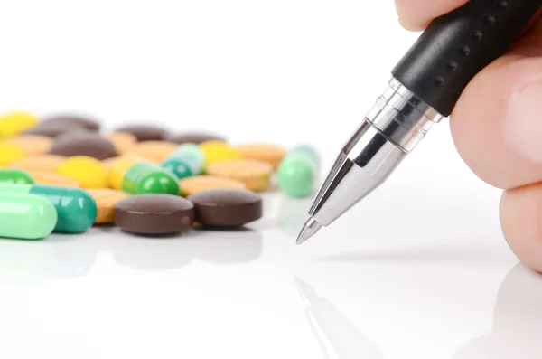 Медицина и ручка на белом фоне — стоковое фото