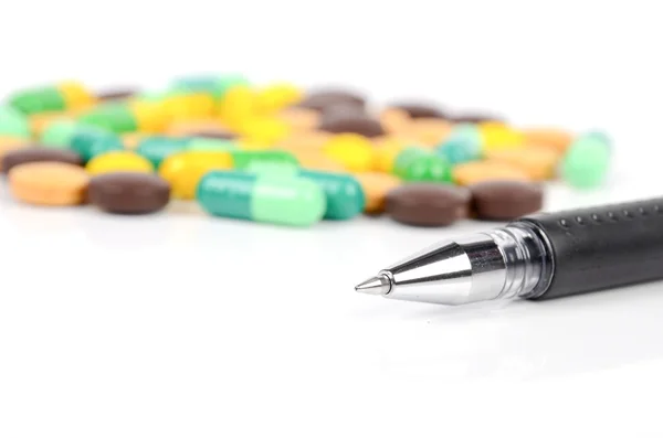 Medicin och penna på vit bakgrund — Stockfoto