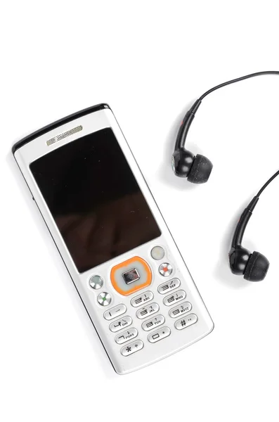 Mobilní telefon a sluchátka na bílém pozadí — Stock fotografie
