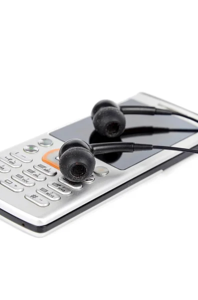 Telefone celular e fone de ouvido no fundo branco — Fotografia de Stock