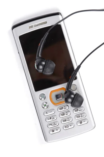 Mobilní telefon a sluchátka na bílém pozadí — Stock fotografie