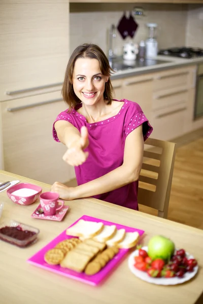 Woman in pajamas having breakfast thumb up — Stock Photo, Image