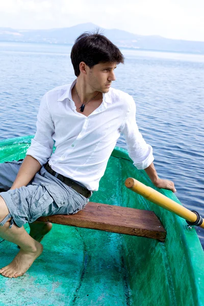 Hombre guapo en barco en un lago — Foto de Stock
