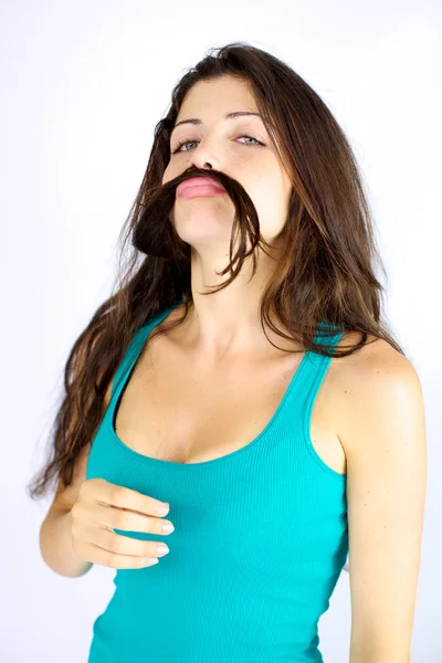 Beautiful woman making funny face with hair as moustache — Stock Photo, Image