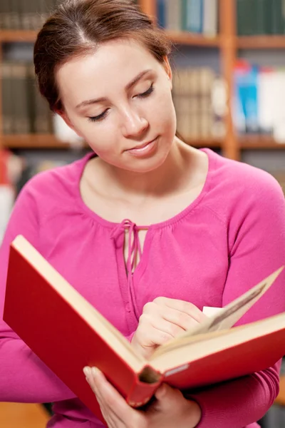 Lány könyvével a könyvtárban — Stock Fotó