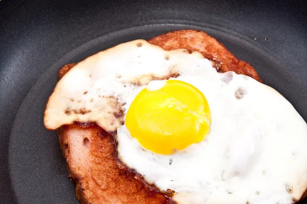Мясной рулет и жареное яйцо в сковороде — стоковое фото