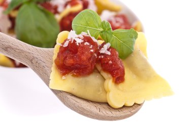 Raviolis with tomato sauce on a wooden spoon clipart