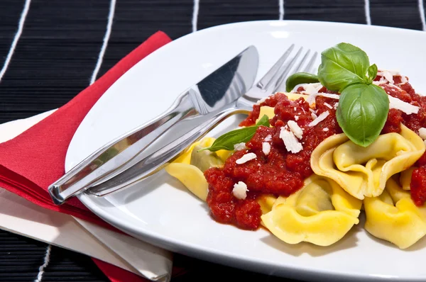 Tortellini on a plate against black background — Stock Photo, Image
