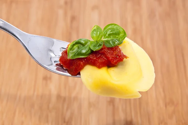 Bir çatalla ahşap arka plan üzerinde tortellini — Stok fotoğraf