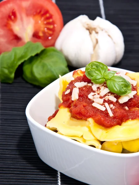 Tortellini with blurred ingredients in the background — Stock Photo, Image