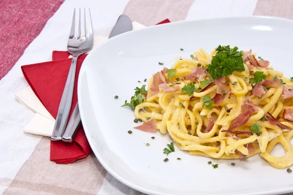Prato com Spaetzle de queijo na toalha de mesa — Fotografia de Stock