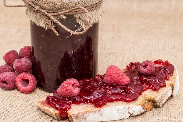 Bread with Raspberry Jam (rustic background) — Stock Photo, Image