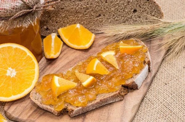 Brot mit Orangenmarmelade (rustikaler Hintergrund)) — Stockfoto