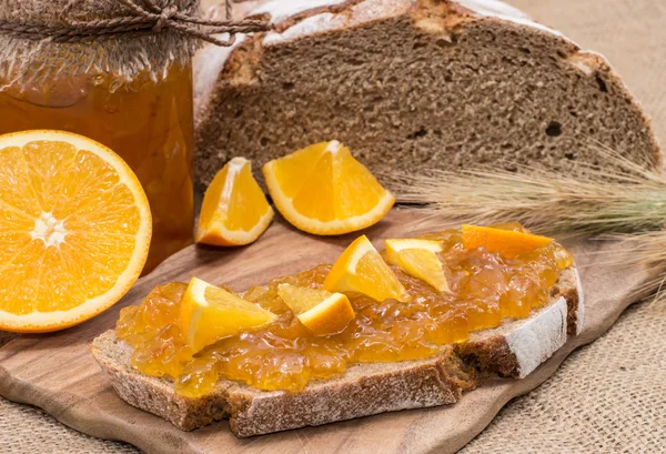 Bread with Orange Jam (rustic background) — Stock Photo, Image