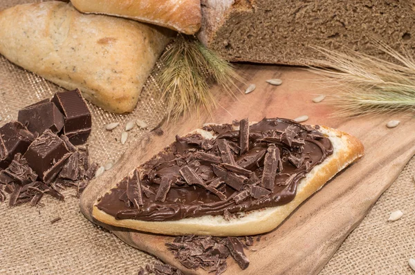 Crema di cioccolato su un panino (sfondo rustico ) — Foto Stock