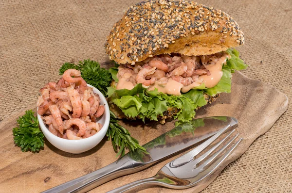 Shrimps on a roll against rustic background — Stock Photo, Image