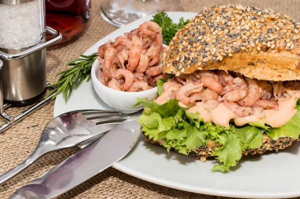 Shrimps on a roll against rustic background — Stock Photo, Image