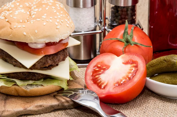 Dobbelt Burger med ingredienser og bestik - Stock-foto