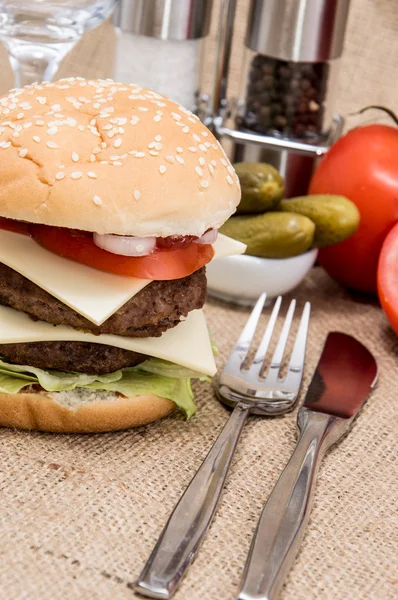 Dobbelt Burger med ingredienser og bestik - Stock-foto