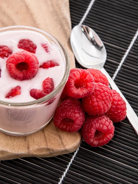 Raspberry yoghurt op zwarte achtergrond — Stockfoto