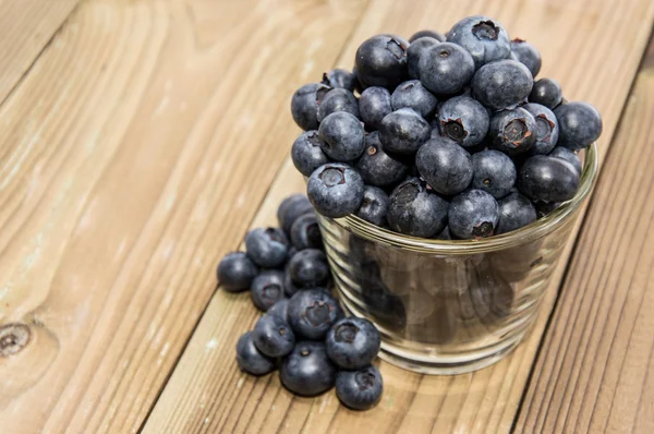 Blueberries in a glass on wood — Stock Photo, Image