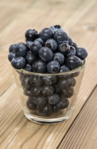 Blueberries in a glass on wood — Stock Photo, Image