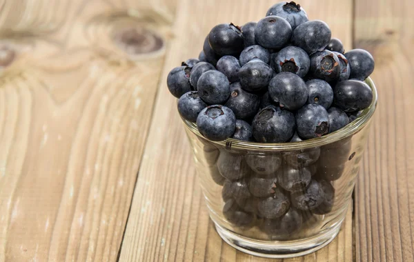 Stock image Blueberries in a glass on wood