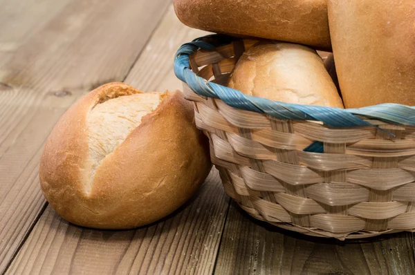 Cesta com pães sobre fundo de madeira — Fotografia de Stock