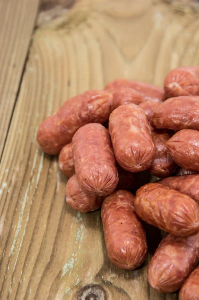 stock image Heap of mini Salamis on wooden background