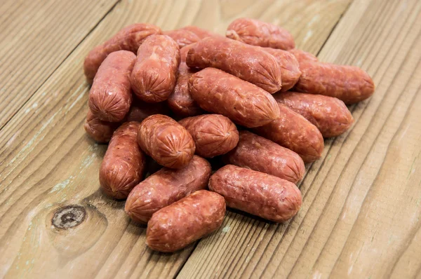 stock image Heap of mini Salamis on wooden background