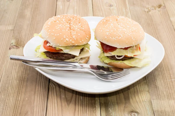 To cheeseburgere på en tallerken - Stock-foto
