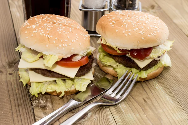 Zwei Cheeseburger auf Holzgrund — Stockfoto