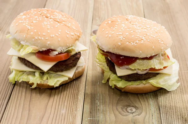 Two Cheeseburger on wooden background — Stock Photo, Image