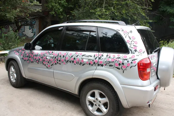 kobiet samochód jest urządzony z różowe kwiaty