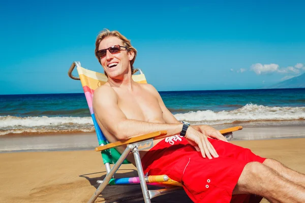 Hombre joven relajándose en la playa — Foto de Stock