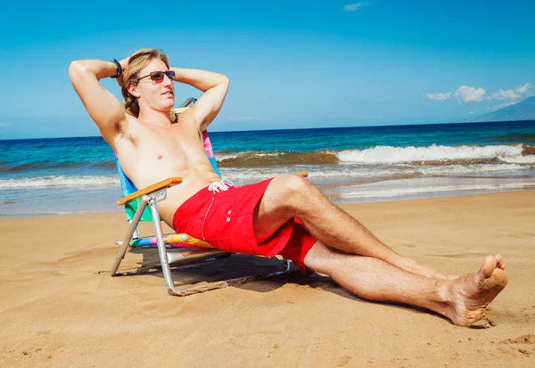 Молодой человек отдыхает на пляже — стоковое фото
